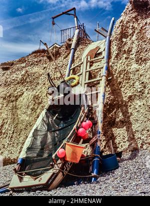 Un paesaggio intimo con stampe artistiche, composto da barca e scaletta sulle scogliere in rovina a Birling Gap, costa meridionale dell'Inghilterra, sotto il sole. Foto Stock