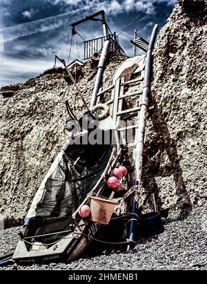 Un paesaggio intimo con stampe artistiche, composto da barca e scaletta sulle scogliere in rovina a Birling Gap, costa meridionale dell'Inghilterra, sotto il sole. Foto Stock