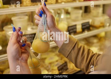 Delizioso Caciocavallo fresco e Scamorza formaggio appeso. Formaggi italiani da vicino. I formaggi sono fatti a mano. La produzione di formaggio Foto Stock