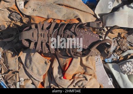 Frammento di sandalo in pelle, scarpa da uomo dilatata sul pavimento, scarpa marciume, scarpa da relitto, scarpa logoro, scarpa logoro Foto Stock