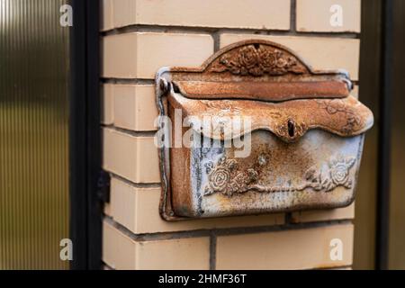 Mailbox di una casa privata, una mailbox in metallo nero installato su una recinzione in mattoni di una casa residenziale privata. Foto Stock