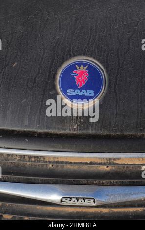 Logo auto Saab su vernice blu, emblema Saab su lamiera auto sporca, vista dettagli, rottami auto, deposito rottami, riciclaggio metalli, rottami di metallo riciclaggio, metallo Foto Stock