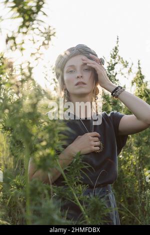 Donna nella pianta di Cannabis, ragazza in piedi con Marijuana o Hem Foto Stock