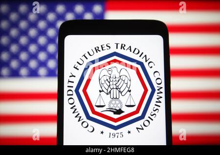 In questa illustrazione della foto, il logo Commodity Futures Trading Commission (CFTC) viene visualizzato sullo schermo di uno smartphone e la bandiera degli Stati Uniti sullo sfondo. Foto Stock