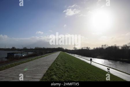 Amburgo, Germania. 07th Feb 2022. Un uomo cammina lungo la diga che conduce allo Spreehafen vicino alla Ernst-August-Schleuse nel distretto di Wilhelmsburg. (A dpa 'Storm Surge 1962: I testimoni contemporanei ricordano l'orrore e l'avventura') Credit: Christian Charisius/dpa/Alamy Live News Foto Stock