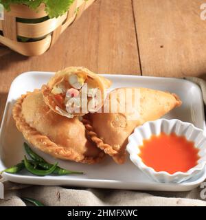 KUE Pastel Goreng (Jalangkote o Karipap) è uno spuntino di pasticceria flaky riempito con carote cubate, patate e uova. Popolare nel sud-est asiatico come Curry pu Foto Stock