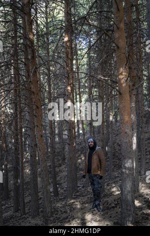 Colpo verticale di un uomo in piedi nella foresta. Foto Stock