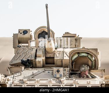 Un soldato degli Stati Uniti dalla 2nd Platoon, Alpha Company, 1/163rd Combined Arms Battaglione, guida un Bradley M2A3 Fighting Vehicle al suo punto di ispezione ad Ali al Salem AB, 27 gennaio 2022. Il veicolo è un veicolo da trasporto completamente cingolato e blindato, che offre mobilità in tutto il paese con potenza di fuoco montata e protezione da artiglieria e fuoco di armi leggere. (STATI UNITI Foto della Guardia Nazionale dell'aria dello staff Sgt. Chloe Ochs) Foto Stock