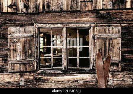 Guardando attraverso una finestra di legno in un rustico salone casale Foto Stock