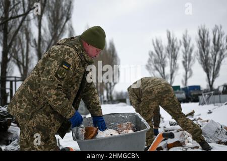 Pokrovsk, Ucraina. 08th Feb 2022. I soldati ucraini tagliano e preparano legna da ardere al di fuori del 66th Military-Mobile Hospital, una struttura sanitaria civile e militare congiunta situata nella città di Pokrovsk nella regione di Donetsk in Ucraina, a soli 25 miglia dal territorio separatista detenuto. 9th febbraio 2022, Pokrovsk, Ucraina. (Foto di Justin Yau/Sipa USA) Credit: Sipa USA/Alamy Live News Foto Stock