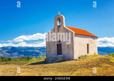 Il paesaggio sotto le montagne del parco nazionale Paklenica, Chiesa di San Vido del 14th secolo, Croazia, Europa. Foto Stock