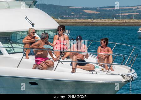 Gruppo di persone ancorate a East Head, West Wittering, godendo del bel tempo e rilassandosi sul bordo anteriore del loro motoscafo.West Sussex, Inghilterra Foto Stock