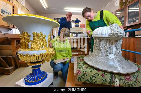 10 febbraio 2022, Brandeburgo, Cottbus: Lilly Neitzke (l-r) sta attualmente facendo un FSJ - anno sociale volontario nella conservazione dei Monumenti, Jens-Uwe Möbert, restauratore, e Marie Schulz, Servizio Volontario federale, Stanno lavorando insieme nel laboratorio di restauro del Parco del Museo Fürst-Pückler e della Fondazione Castello Branitz su magnifici vasi di crateri del Castello di Branitz. Attualmente, il laboratorio di restauro della Fondazione Prince-Pückler-Museum Park e Castello Branitz sta restaurando quattro magnifici vasi crateri dalla terrazza del castello. Questi sono due vasi di argilla originali e due repliche. Il vaso Foto Stock