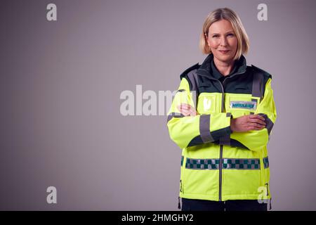 Studio Ritratto di sorridere Femminile Paramedico contro sfondo normale Foto Stock