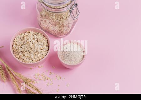 Ingredienti per fare la maschera facciale fatta in casa o scrub. Ciotola di fiocchi d'avena secchi con farina d'avena e spighe di frumento Foto Stock