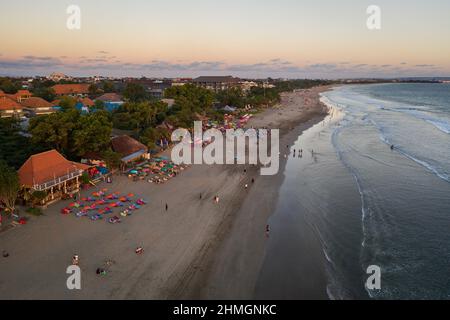 Vista aerea del tramonto sulla famosa spiaggia di Seminyak con bar sulla spiaggia a Kuta, nella zona sud di Bali, in Indonesia Foto Stock
