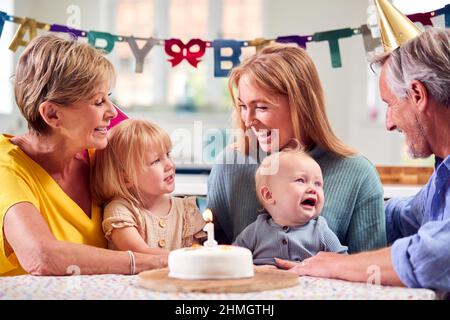 Nonni con madre e nipoti festeggiano con il primo compleanno Party a casa Foto Stock