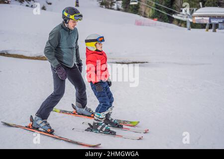 Ragazzo imparando a sciare, allenandosi e ascoltando il suo maestro di sci sulla pista in inverno Foto Stock