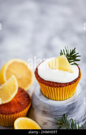Deliziosi cupcake al limone fatti in casa, decorati con formaggio cremoso e agrumi freschi Foto Stock