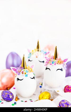 Uova di Pasqua in forma di unicorno su sfondo bianco, spazio di copia per il testo, primo piano Foto Stock