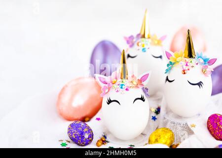 Uova di Pasqua in forma di unicorno su sfondo bianco, spazio di copia per il testo, primo piano Foto Stock