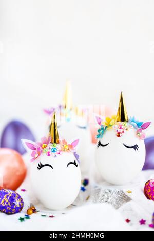 Uova di Pasqua in forma di unicorno su sfondo bianco, spazio di copia per il testo, primo piano Foto Stock