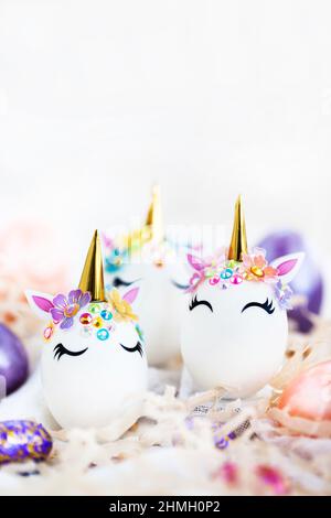 Uova di Pasqua in forma di unicorno su sfondo bianco, spazio di copia per il testo, primo piano Foto Stock