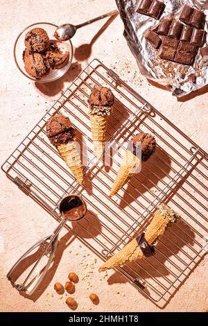 Gelato al cioccolato su una rastrelliera metallica con cucchiaio di acciaio inossidabile, fuoco selettivo, primo piano Foto Stock