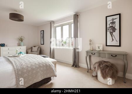 Newport, Essex - Marzo 21 2019: Camera da letto moderna di lusso all'interno della nuova casa vacante con copriletto e tavolino laterale Foto Stock