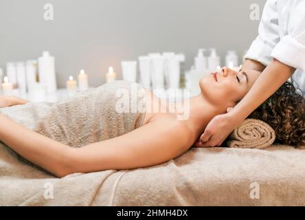 Giovane bella donna che gode di massaggio nel salone di bellezza in un concetto di salute e bellezza Foto Stock