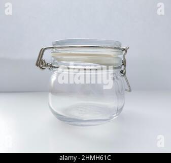 Vaso in vetro vuoto per spezie con coperchio su sfondo bianco Foto Stock