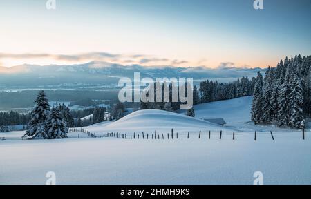 Paesaggio invernale innevato prima dell'alba. Vista sull'Illertal e sulle Alpi Allgäu con la Grünten. Baviera, Germania, Europa Foto Stock
