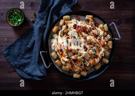 Vista dall'alto della tater tot poutine appena fuori dal forno, pronta per la condivisione. Foto Stock