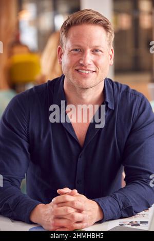Ritratto di uomo d'affari sorridente che lavora al tavolo in Office Coffee Shop Foto Stock
