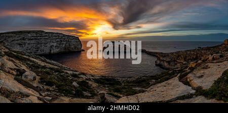 Il sole tramonta in colori gloriosi sulla Baia di Dwejra a Gozo Foto Stock