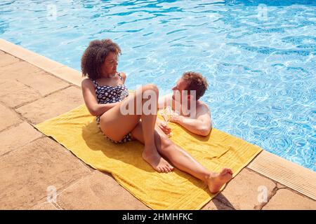 Coppia romantica che beve Champagne in piscina in vacanza Foto Stock