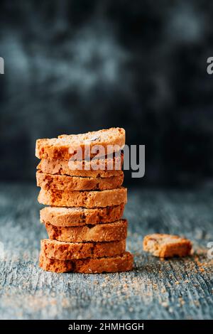 un mucchio di carquinioli, biscotti di mandorle tipici della catalogna, spagna, simili ai biscotti italiani, su un tavolo grigio rustico in legno Foto Stock