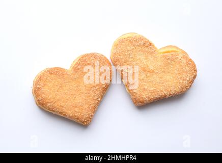 Due biscotti in zucchero a forma di cuore su sfondo bianco. Concetto di San Valentino Foto Stock