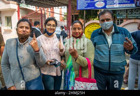 Ghaziabad, India. 10th Feb 2022. I membri della famiglia hanno visto mostrare le loro dita inchinate dopo aver castrato le loro urne in un seggio elettorale nella città di Ghaziabad durante la prima fase delle elezioni dell'assemblea di stato di Uttar Pradesh. Credit: SOPA Images Limited/Alamy Live News Foto Stock