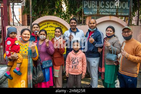 Ghaziabad, India. 10th Feb 2022. I membri della famiglia hanno visto mostrare le loro dita inchinate dopo aver castrato le loro urne in un seggio elettorale nella città di Ghaziabad durante la prima fase delle elezioni dell'assemblea di stato di Uttar Pradesh. Credit: SOPA Images Limited/Alamy Live News Foto Stock