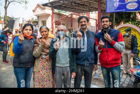 Ghaziabad, India. 10th Feb 2022. I membri della famiglia hanno visto mostrare le loro dita inchinate dopo aver castrato le loro urne in un seggio elettorale nella città di Ghaziabad durante la prima fase delle elezioni dell'assemblea di stato di Uttar Pradesh. Credit: SOPA Images Limited/Alamy Live News Foto Stock