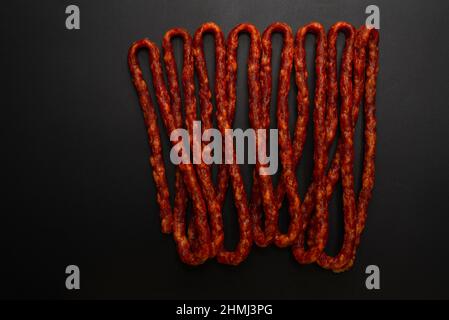 Cabanossi, salsiccia secca isolato su sfondo nero. Foto Stock