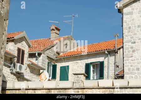 Tetti di tegole rosse con antenne sulle vecchie case della città vecchia in Montenegro. Foto Stock