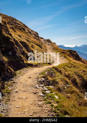 Sentiero escursionistico in montagna che conduce lungo un ripido pendio, verso il cielo, preso in Vallese, Svizzera Foto Stock
