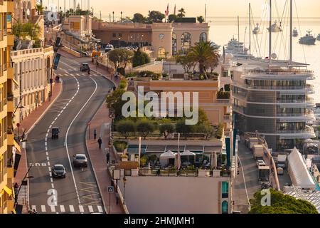 Paesaggio urbano della strada principale lungo il porto di Ercole nel Principato di Monaco al mattino, Monte-Carlo, poche auto e persone, enorme motore Foto Stock