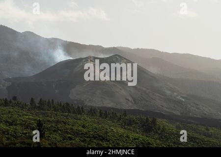 Vista del vulcano Cumbre Vieja che ancora emette gas di zolfo. Molte aree sono ancora colpite dalla lava vulcanica e dalle ceneri Foto Stock