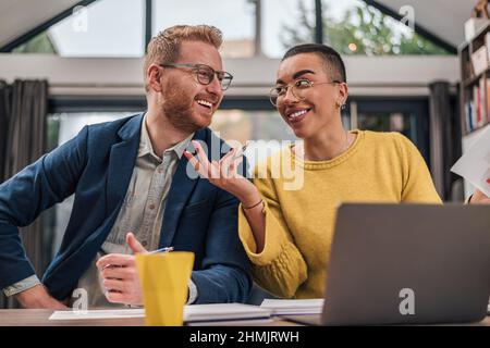 Sorridendo felice ridendo allegro soddisfatto coppia di uomini d'affari diversi che fanno lavoro di ufficio insieme e una nuova piccola impresa iniziare a planare mentre worki Foto Stock