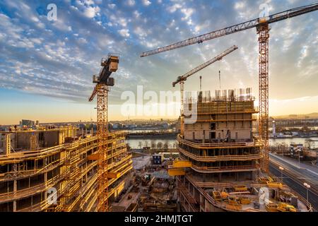 Wien, Vienna: Tramonto del fuoco nel sito di costruzione di un'alta casa di appartamenti, fiume Neue Donau (nuovo Danubio, fronte), Donau (Danubio), isola Donauinsel, Foto Stock