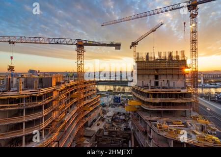 Wien, Vienna: Tramonto del fuoco nel sito di costruzione di un'alta casa di appartamenti, fiume Neue Donau (nuovo Danubio, fronte), Donau (Danubio), isola Donauinsel, Foto Stock