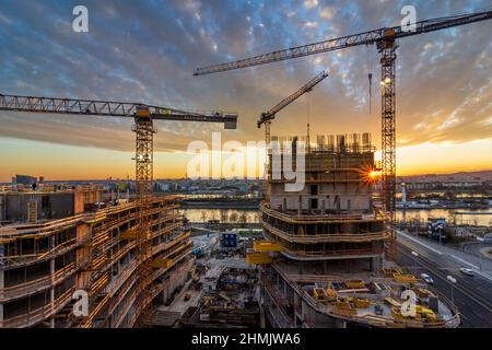 Wien, Vienna: Tramonto del fuoco nel sito di costruzione di un'alta casa di appartamenti, fiume Neue Donau (nuovo Danubio, fronte), Donau (Danubio), isola Donauinsel, Foto Stock